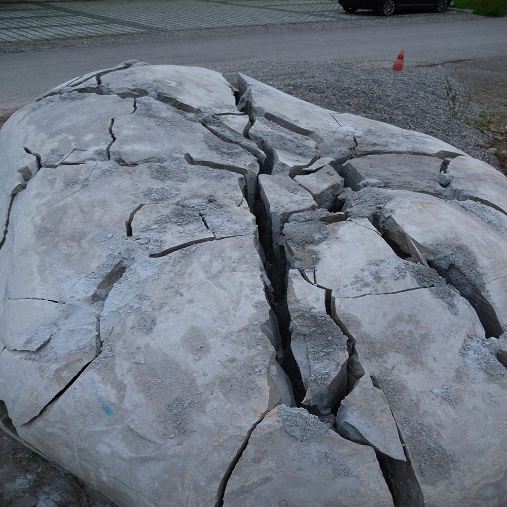 Large boulder next to a driveway split under control