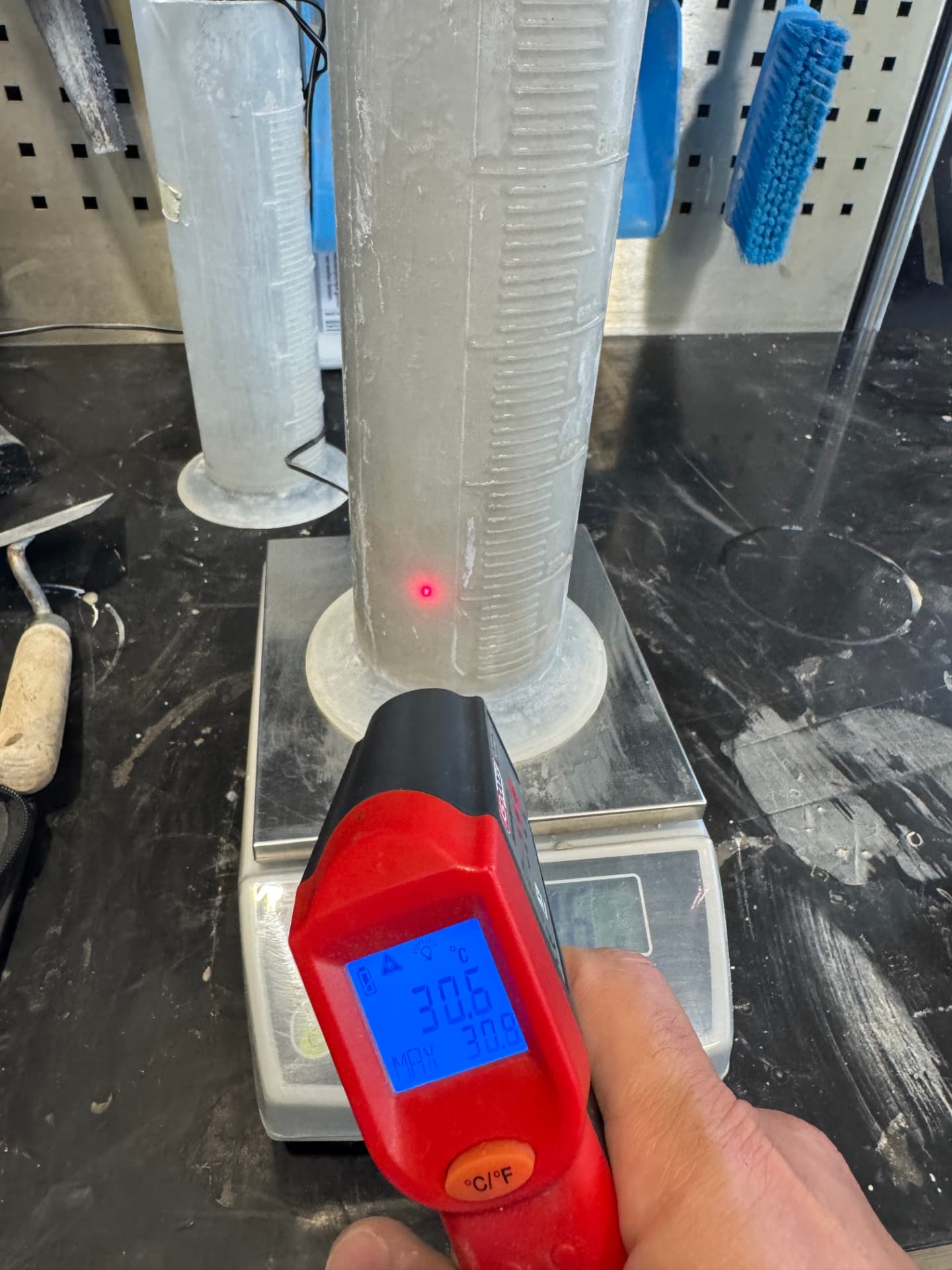 Infrared thermometer showing 30.6 °C in the mixed BETONAMIT mass