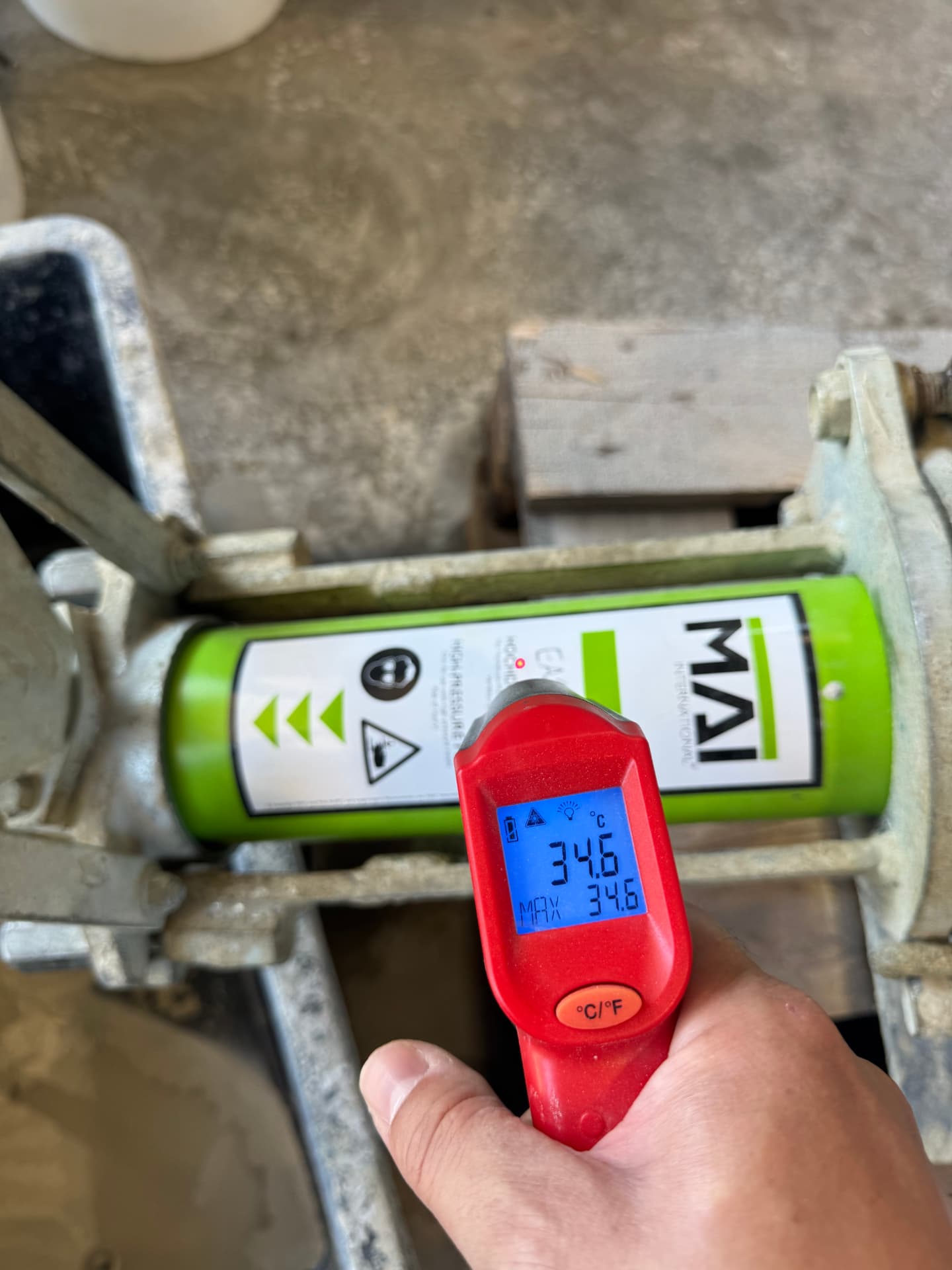 Infrared thermometer showing 34.6 °C on the housing of the mixing pump